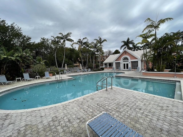 pool featuring fence and a patio area