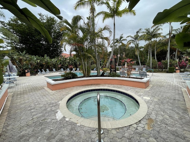 community pool with a patio and a community hot tub