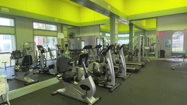 exercise room featuring visible vents and a towering ceiling