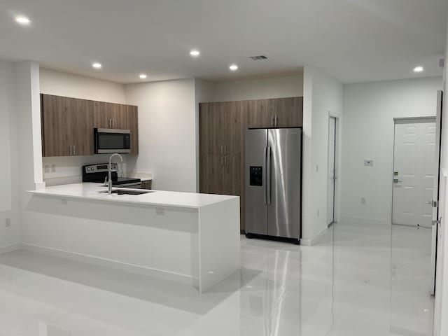 kitchen with modern cabinets, recessed lighting, stainless steel appliances, a peninsula, and light countertops