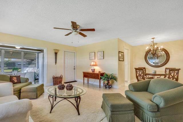 living area featuring light tile patterned floors, baseboards, a textured ceiling, and ceiling fan with notable chandelier