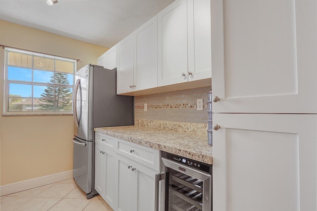 kitchen featuring beverage cooler, light countertops, tasteful backsplash, and white cabinetry