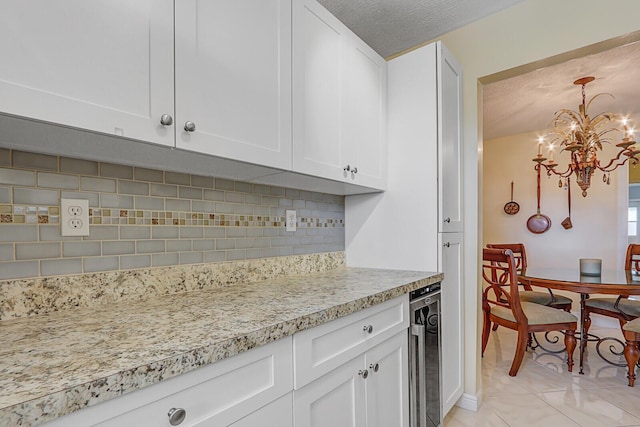 kitchen featuring light tile patterned floors, backsplash, white cabinets, a textured ceiling, and beverage cooler