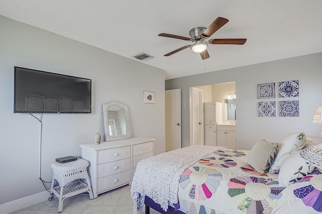 bedroom with a ceiling fan, light tile patterned flooring, visible vents, and ensuite bathroom