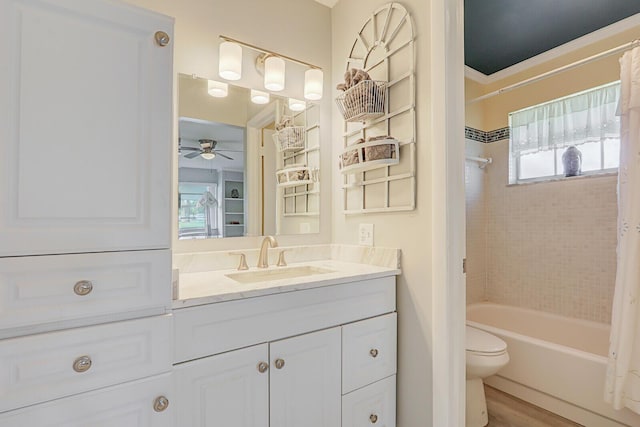 full bathroom with toilet, shower / bath combo with shower curtain, a ceiling fan, vanity, and wood finished floors