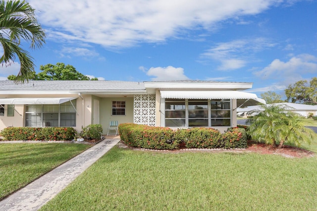 view of front facade featuring a front lawn and stucco siding