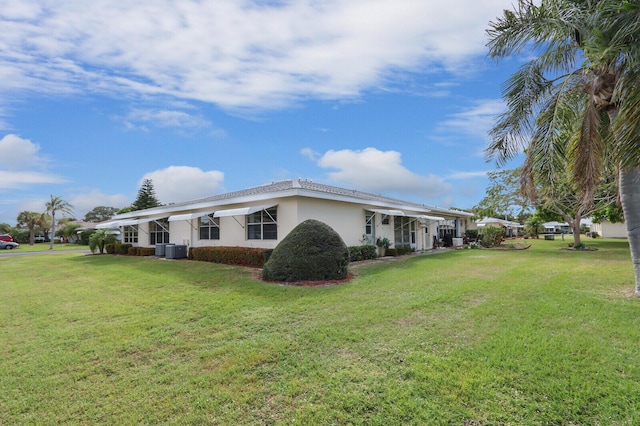 view of property exterior featuring a yard, central AC, and stucco siding