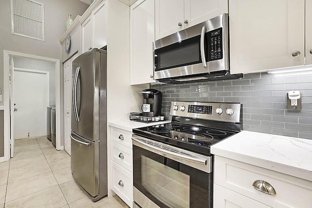 2045 NW 127th Ter, Coral Springs, FL 33071 - kitchen with light tile patterned flooring, white cabinetry, backsplash, and appliances with stainless steel finishes