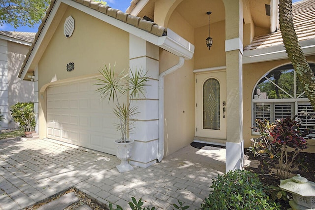 2045 NW 127th Ter, Coral Springs, FL 33071 - property entrance with stucco siding, an attached garage, a tile roof, and driveway