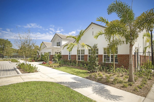 2045 NW 127th Ter, Coral Springs, FL 33071 - view of front facade featuring brick siding, a front yard, stucco siding, and fence
