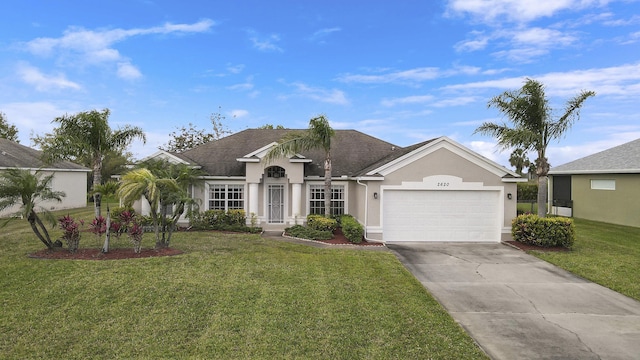 view of front of property featuring an attached garage, a front yard, and stucco siding