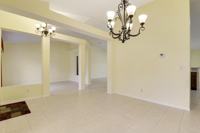 empty room featuring light tile patterned floors, baseboards, and a notable chandelier