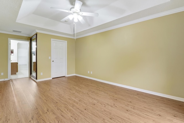 empty room featuring light wood-style floors, baseboards, visible vents, and a ceiling fan