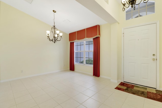 entrance foyer featuring a chandelier, light tile patterned flooring, vaulted ceiling, and baseboards