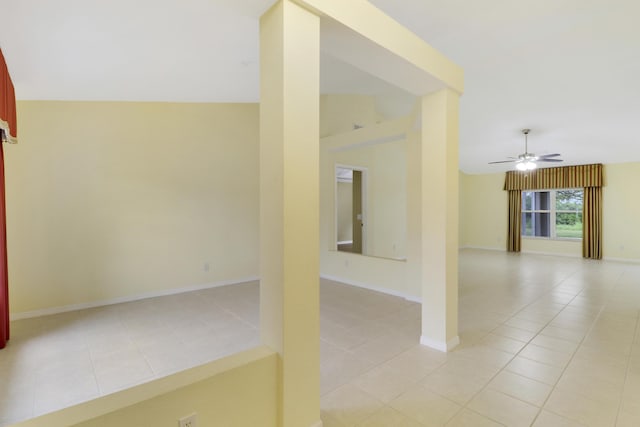 spare room with lofted ceiling, ceiling fan, baseboards, and light tile patterned floors