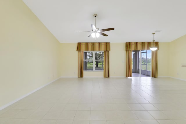 spare room with light tile patterned floors, baseboards, vaulted ceiling, and a ceiling fan