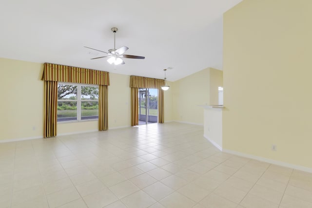 unfurnished room featuring lofted ceiling, ceiling fan, baseboards, and light tile patterned floors