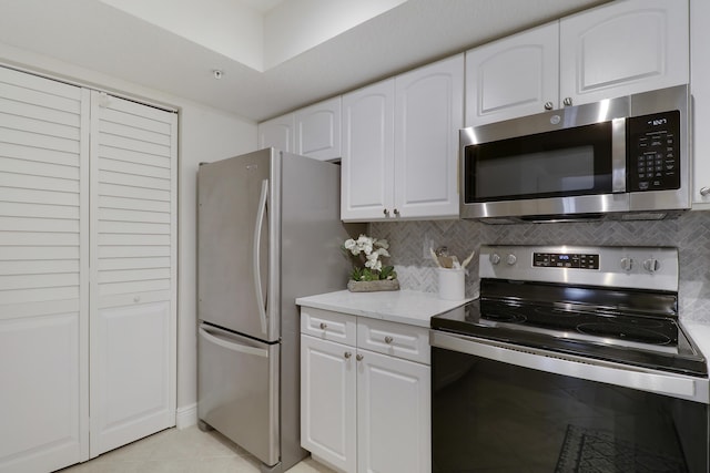 kitchen featuring light stone counters, backsplash, stainless steel appliances, white cabinets, and light tile patterned flooring