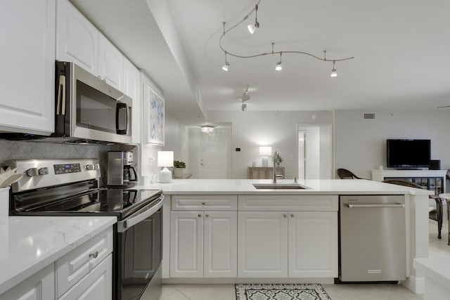 kitchen with visible vents, a sink, open floor plan, appliances with stainless steel finishes, and white cabinets