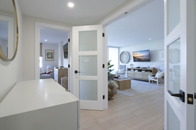 corridor featuring light wood-type flooring and recessed lighting