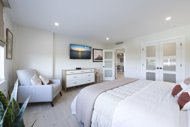 bedroom with light wood finished floors, recessed lighting, and french doors