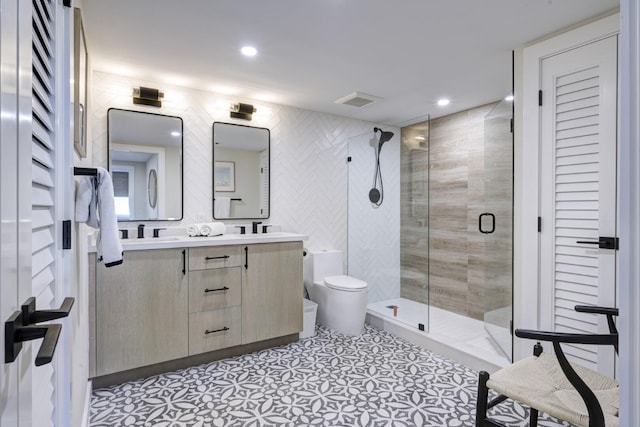 full bathroom featuring double vanity, visible vents, toilet, a sink, and a shower stall