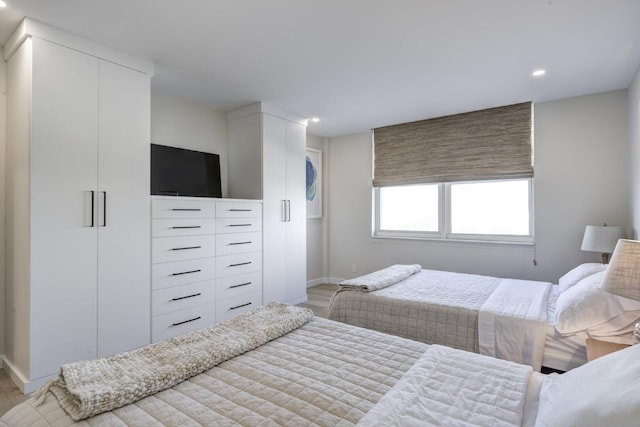 bedroom featuring baseboards, light wood-type flooring, and recessed lighting