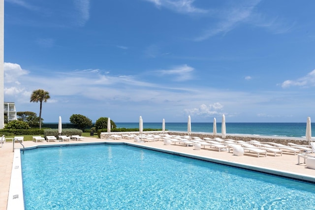 pool with a patio area and a water view