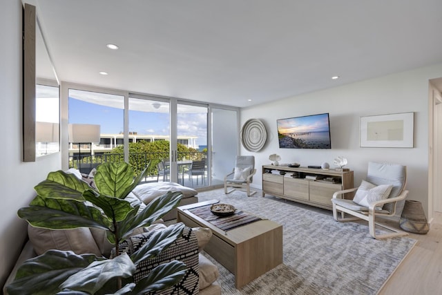 living area featuring recessed lighting, expansive windows, and wood finished floors