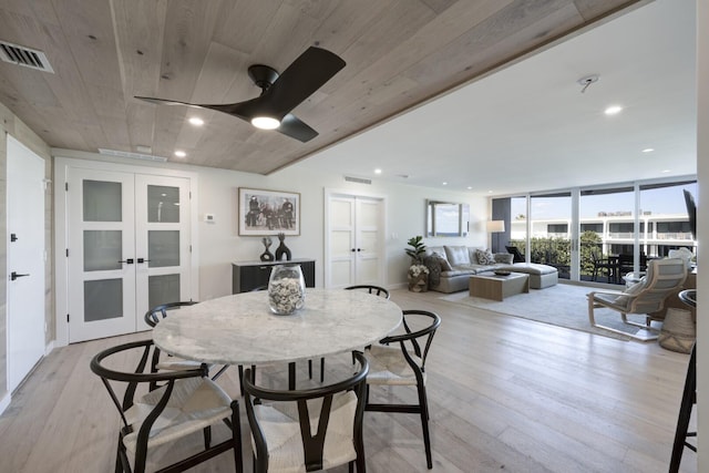 dining space with french doors, a wall of windows, light wood-type flooring, and visible vents