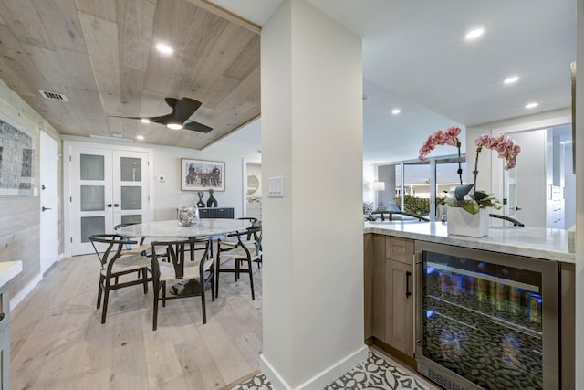 interior space with wooden ceiling, beverage cooler, visible vents, light wood-style floors, and french doors