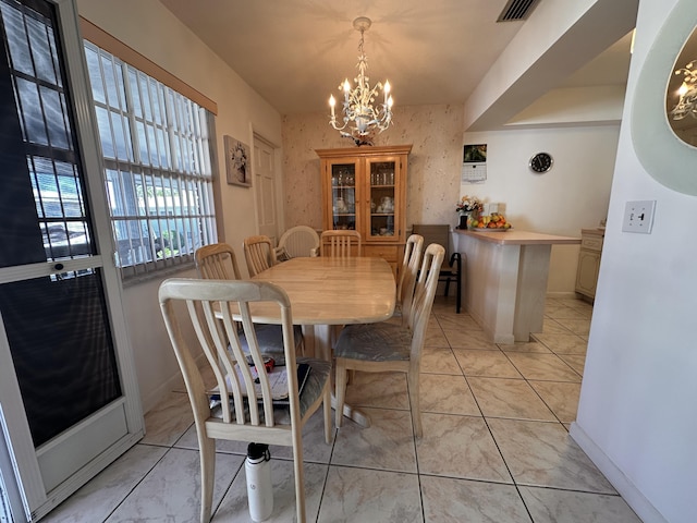 dining room with wallpapered walls, light tile patterned floors, visible vents, baseboards, and a chandelier