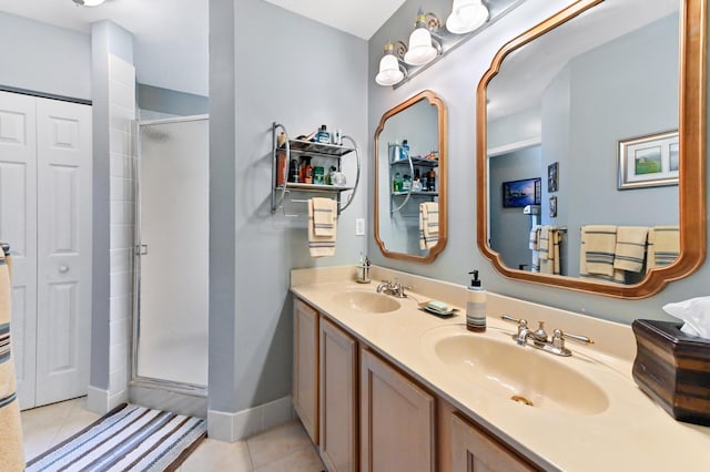 bathroom featuring double vanity, a sink, a shower stall, and tile patterned floors