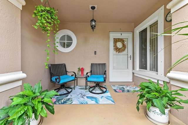 doorway to property with a porch and stucco siding