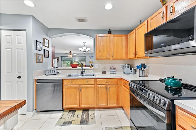 kitchen featuring arched walkways, stainless steel appliances, a sink, visible vents, and light countertops