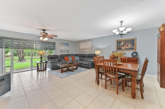 dining space with light tile patterned flooring, a textured ceiling, baseboards, and ceiling fan with notable chandelier