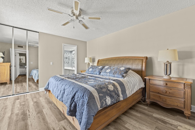 bedroom featuring visible vents, connected bathroom, ceiling fan, a textured ceiling, and wood finished floors