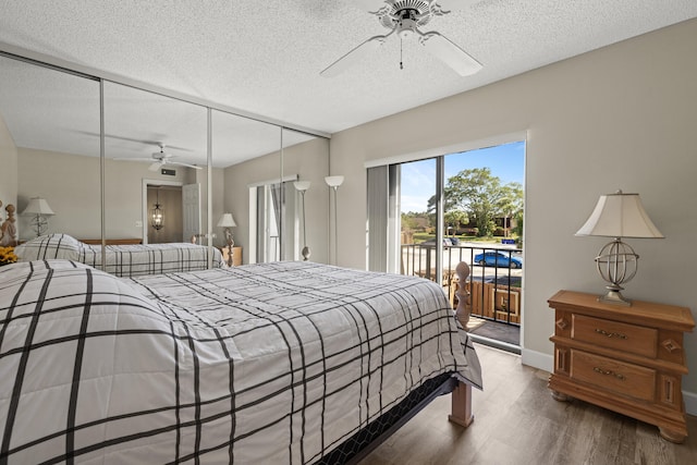 bedroom featuring access to exterior, a ceiling fan, a textured ceiling, and wood finished floors