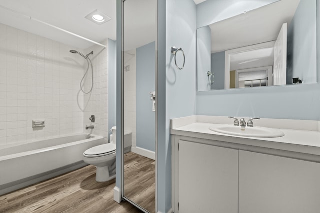 full bath with  shower combination, vanity, toilet, and wood finished floors