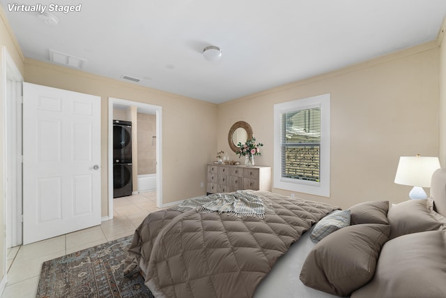 1204 Easter Ave, Fort Pierce, FL 34950 - bedroom with stacked washer and clothes dryer, light tile patterned floors, crown molding, and baseboards