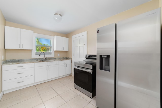1204 Easter Ave, Fort Pierce, FL 34950 - kitchen with appliances with stainless steel finishes, a sink, white cabinetry, light stone counters, and light tile patterned flooring