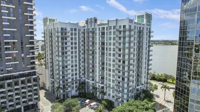 view of building exterior featuring a water view and a city view