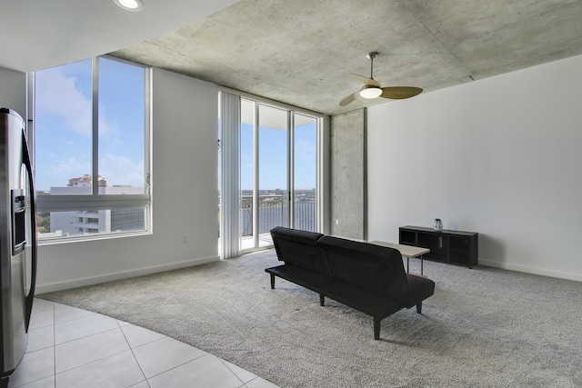 living area with light carpet, plenty of natural light, and baseboards