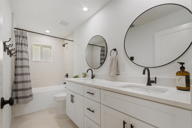 bathroom featuring shower / bath combination with curtain, a sink, toilet, and double vanity