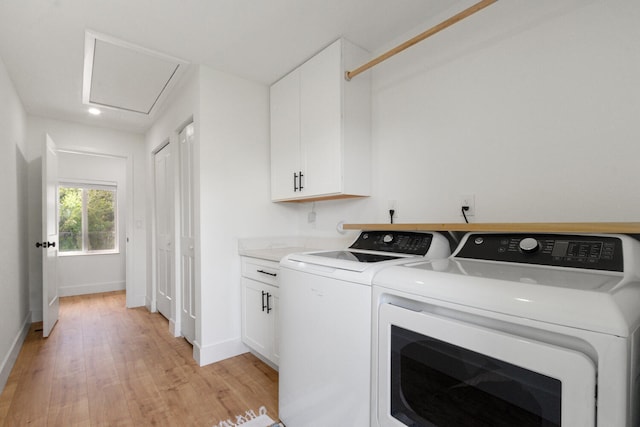 laundry room with baseboards, washer and clothes dryer, cabinet space, and light wood-style floors