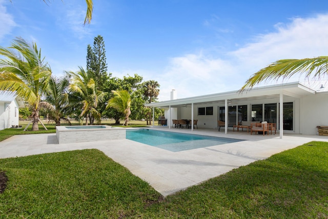 pool featuring a patio area, a yard, and an in ground hot tub