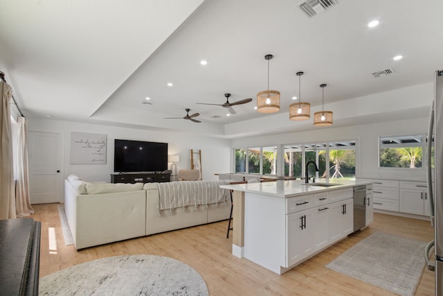 kitchen featuring dishwasher, light wood-type flooring, a sink, and visible vents