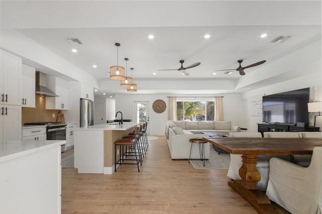 living area with recessed lighting, visible vents, and light wood-style floors