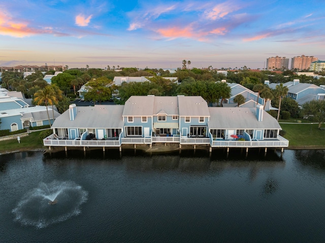 aerial view at dusk featuring a water view