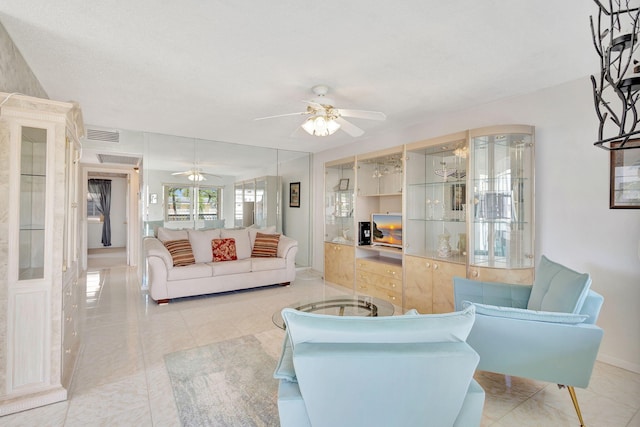 living room featuring ceiling fan, light tile patterned flooring, visible vents, and baseboards